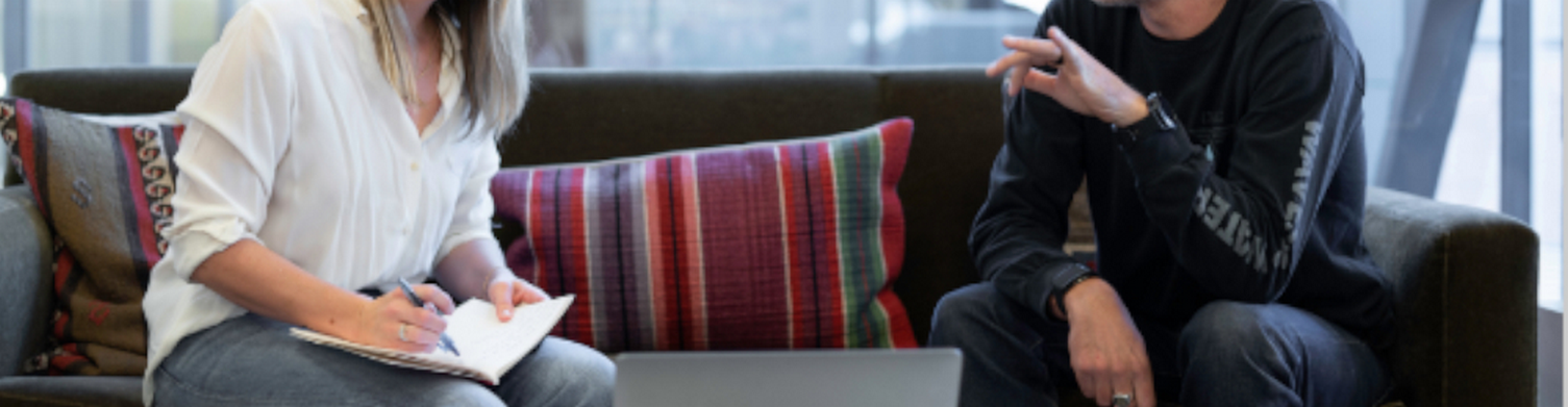 man and woman on couch in conversation